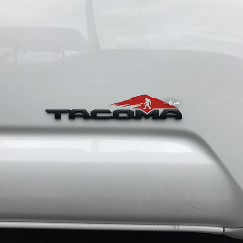 Etiqueta engomada de las montañas de Toyota Tacoma sobre la insignia Tacoma 2
